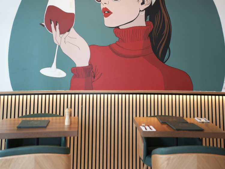 Inside Rasa: the mural of a woman raising a glass of wine above the timber-slat wall and the set tables