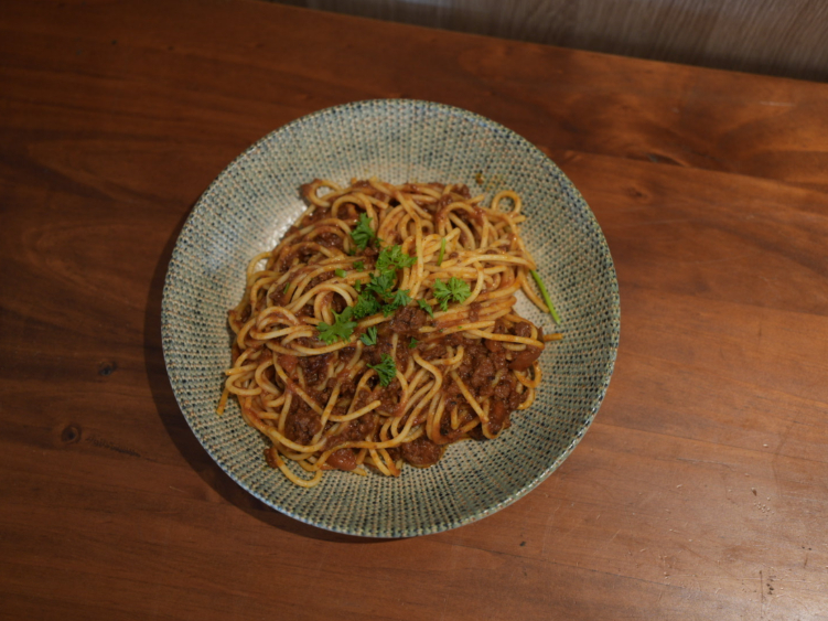 Spaghetti bolognese topped with fresh parsley